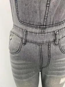 Close-up view of grey washed denim overalls showing waist detail and fabric texture.
