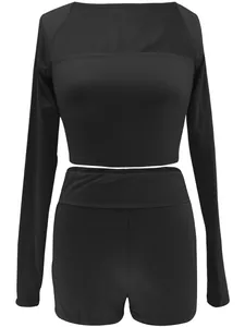 Gedetailleerd vooraanzicht van een zwarte damesset met crop top met lange mouwen en short.
