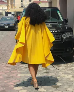 Vue arrière d'une robe plissée jaune surdimensionnée à manches chauve-souris en plein air