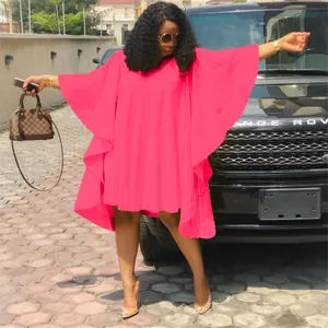Vue détaillée d'une robe fuchsia grande taille à manches chauve-souris en extérieur.