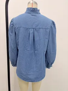 Detailed back view of a blue denim shirt with ruffle collar and elegant puff sleeves.