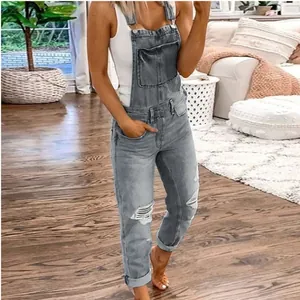 Fashionable grey distressed denim overalls for women in a cozy home setting