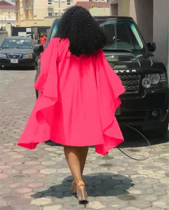 Vue arrière détaillée d'une robe fuchsia plissée à manches chauve-souris dans la rue