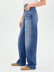 Détail de la vue latérale d'un jean en denim bleu délavé ample pour femme de style décontracté.