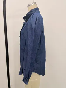 Side profile detail of blue denim shirt featuring a ruffle collar and elegant puff sleeves