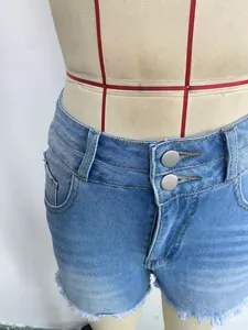 Detalle de los shorts vaqueros de talle alto con doble botón y dobladillo deshilachado