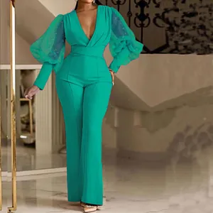 Elegante tuta turchese con maniche a sbuffo in mesh trasparente e scollo a V profondo