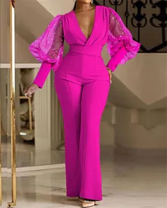 Dettaglio della tuta fucsia con maniche a sbuffo in rete glitterata e profondo scollo a V