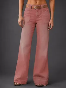 Vue détaillée d'un jean en denim à jambes larges rose poudré avec une ceinture marron.