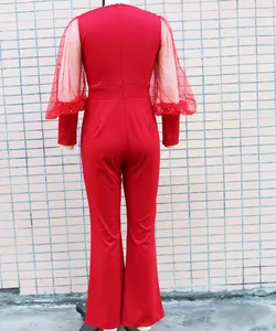 Dettaglio posteriore di tuta rossa con maniche a sbuffo in mesh e gamba larga moda.