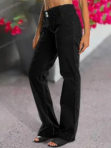 Détail d'un jean noir à jambe droite avec un design à double bouton élégant.