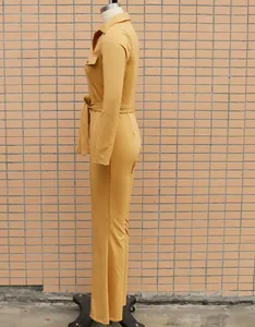 Side view detail of mustard yellow long sleeve commuter jumpsuit with waist belt detail.