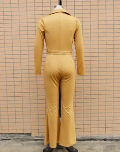 Rear view of a stylish mustard yellow long-sleeved jumpsuit with wide-leg flare pants.