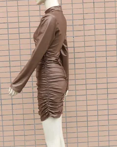 Détail d'une robe moulante froncée en similicuir marron à manches longues