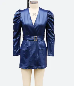 Detailed view of navy blue faux leather dress with deep V-neck and puff sleeves