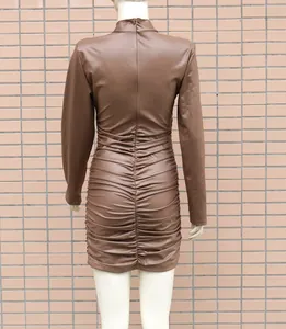 Gros plan du dos d'une robe moulante froncée en simili cuir marron à manches longues