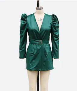 Detail view of a dark green faux leather mini dress with V-neck and puff sleeves
