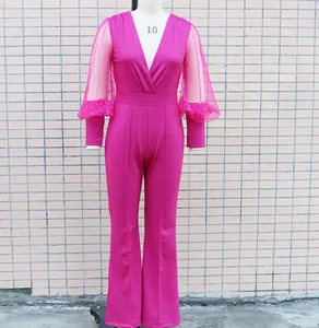Dettaglio della tuta fucsia a gamba larga con maniche a sbuffo in rete e strass