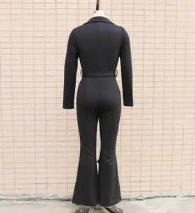 Back view of black long-sleeved commuter jumpsuit with flared legs and waist belt