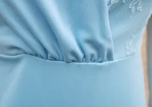 Macro view of light blue lace stitching and elegant ruched waist detail on a slim dress