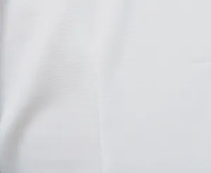 Detalle de primer plano de la textura de la tela blanca y costura del vestido blazer.