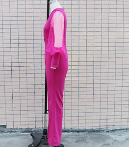Vista laterale di una tuta fucsia con maniche in rete trasparente decorata con strass