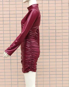 Détail de côté d'une robe moulante rouge vin à manches longues en similicuir plissé