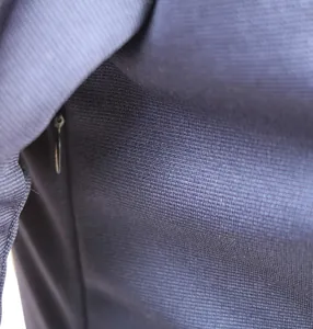 Close-up of navy blue elegant dress showing invisible zipper and premium knit texture.