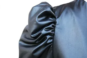 Nahaufnahme des glänzenden Puffärmels aus Kunstleder mit elegantem, gefaltetem Design-Detail