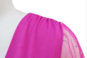 Dettaglio ravvicinato di una tuta fucsia con maniche in rete e paillettes