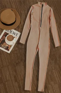 Detailed macro view of the ribbed texture and zipper on the tan athletic jumpsuit.