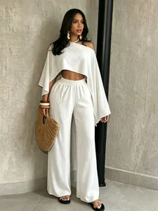 Elegante conjunto blanco de dos piezas con top asimétrico y pantalones de pierna ancha