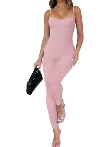 Professional studio shot of a pink ribbed backless jumpsuit with a black handbag