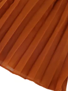 Macro detail view showing fine pleated texture and hem of orange wide-leg trousers