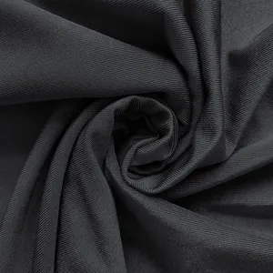 Close-up of black ribbed fabric showing soft texture and rose-like spiral fold.