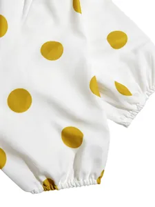 Detalle del puño elástico en un vestido blanco de manga abullonada con grandes lunares amarillos