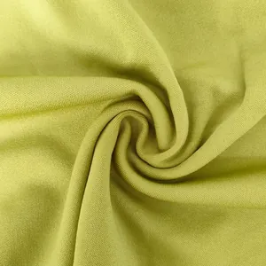 Macro view of lime green knit fabric texture showing fine weave and soft drape detail.