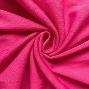 Close-up of bright pink knitted fabric texture showing fine weave and soft drape.