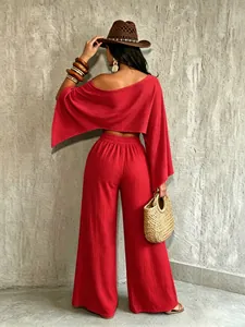 Vista trasera de un conjunto de vacaciones rojo de dos piezas con top descubierto y pantalón ancho