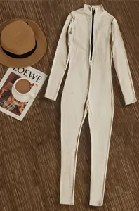 Detailed flat lay of a ribbed beige jumpsuit featuring a front half-zip and long sleeves