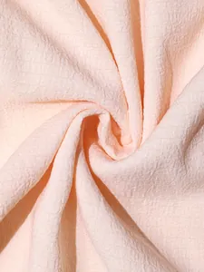 Vista macro detallada de la textura de tela seersucker rosa claro para conjunto mujer
