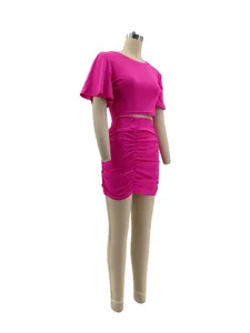 Vibrant pink two-piece set featuring crop top and ruched bodycon skirt on mannequin