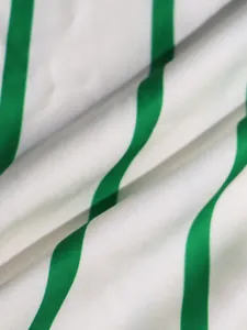 Detalle de cerca de la tela a rayas verticales verdes y blancas para vestido camisero.