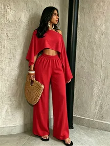 Elegante conjunto rojo de dos piezas con top asimétrico y pantalones de pierna ancha