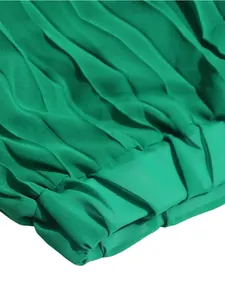 Close-up detail of vibrant green pleated fabric showing fine texture and elegant drape