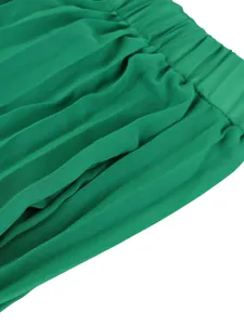 Close-up detail of the elastic waistband and pleated fabric texture on green wide-leg trousers