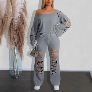 Trendy grey distressed two-piece set featuring off-shoulder ripped sweatshirt and pants.