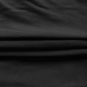 Close-up of black elastic knit fabric texture for office dress, showing soft drape detail.
