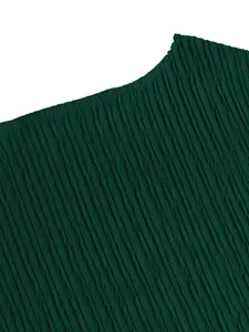Macro detail of dark green pleated fabric showing vertical textured ripples on a garment.