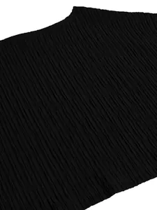 Detailed macro shot of the black pleated fabric texture for this elegant one-shoulder outfit